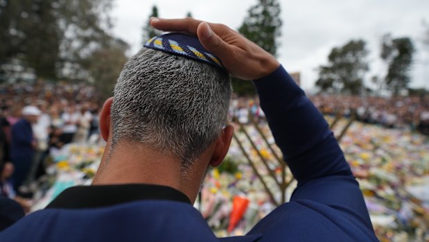 A man mourns during a menorah lighting ceremony on December 16 at the floral memorial for victims of the Bondi Beach attack.