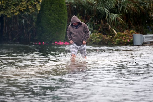A man wades through a flooded section of a road in Long Branch, New Jersey.