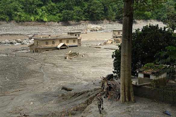 Nepalese Army soldiers survey the devastation in Dhunge.