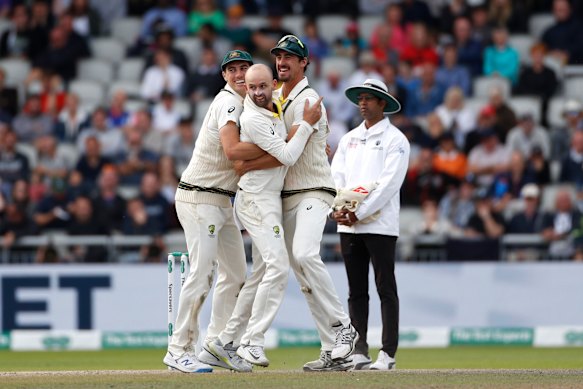 Nathan Lyon celebrates with Pat Cummins and Mitchell Starc. 