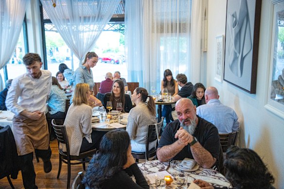 White tablecloths and bistro curtains add a timeless quality to the Victorian-era shopfront.