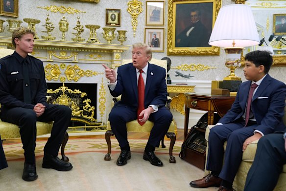 Trump in the Oval Office on Monday, where he met with lifeguard Ryder Williams, left.