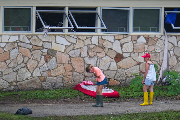 People react as they inspect an area outside the sleeping quarters at Camp Mystic.