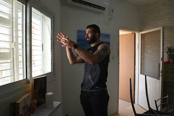 Martial arts fighter Rafael Aronov looks out of the damaged window of his home that was affected after a nearby apartment building was hit by an Iranian ballistic missile in Beersheba on Tuesday.
