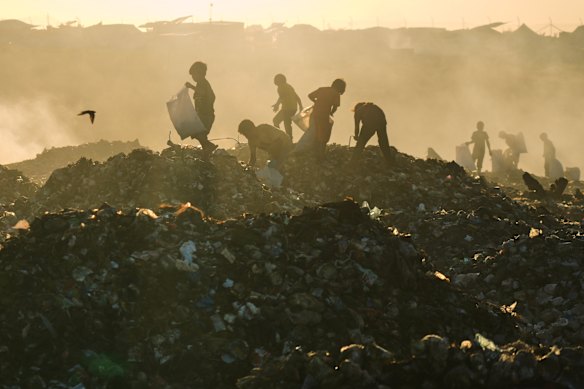 Displaced Palestinian children search for firewood and plastic in a landfill beside the makeshift tent camp in Khan Younis, in the southern Gaza Strip, on Tuesday.