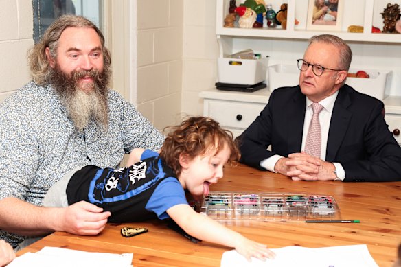 Anthony Albanese speaks with a family in Melbourne on Monday as he sought to capitalise on the Coalition’s work from home blunder.