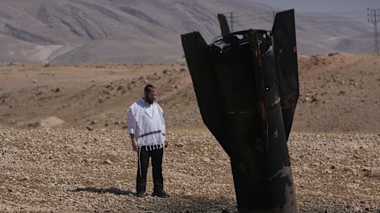 A man looks at the wreckage of an Iranian missile that landed near the West Bank city of Jericho on Monday.