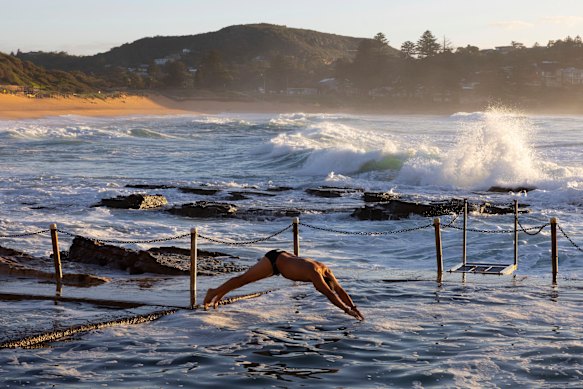 A man dives into the ocean pool.