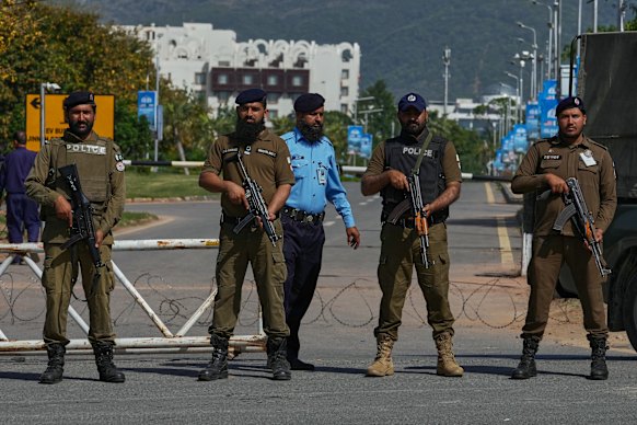 Police officers stand guard at a checkpoint to ensure security ahead of the second round of negotiations between the U.S. and Iran, in Islamabad, Pakistan.