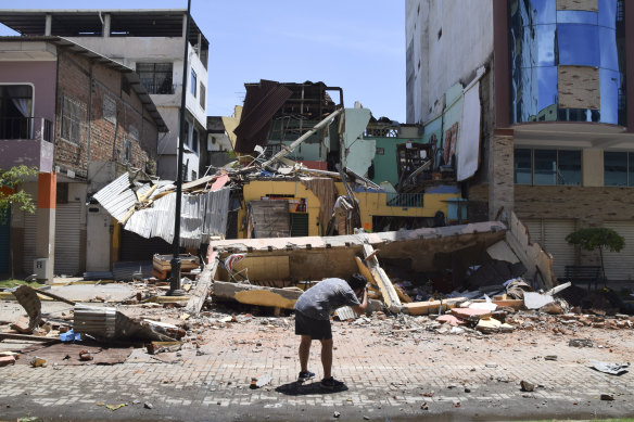 A antheral   photographs a gathering  that collapsed aft  an earthquake shook Machala, Ecuador connected  Saturday.