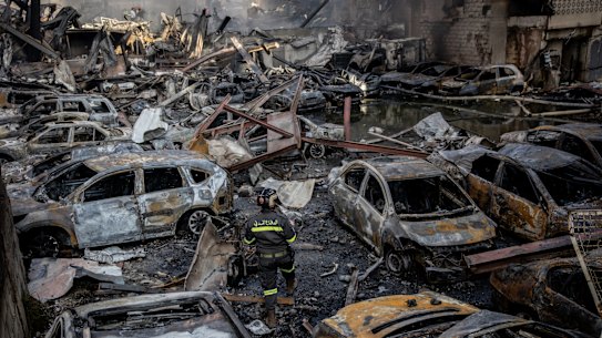 BEIRUT, LEBANON - APRIL 08: A firefighter walks through destroyed cars as a building burns after an Israeli airstrike on April 08, 2026 in Beirut, Lebanon. Israel has stepped-up its attacks on Lebanon following President Donald Trump’s announcement of a two-week ceasefire agreement between the US and Iran, conditional on shipping being allowed to resume through the Strait of Hormuz. Israel says it will observe the ceasefire with Iran but insists Lebanon was not included in the deal, and has since launched the “largest coordinated strike” on Hezbollah targets since the cross-border war began on March 2. Iran and Pakistan - which has been coordinating peace talks - have said that the ceasefire would include Lebanon, while the US has yet to weigh-in. (Photo by Chris McGrath/Getty Images)