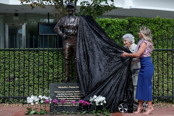 Michelle Payne and Lady Marigold Southey unveil a statue of Payne at Flemington Racecourse.