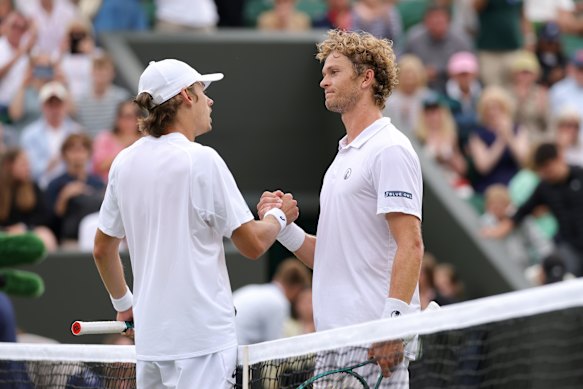 Alex De Minaur greets August Holmgren at the net following his victory.