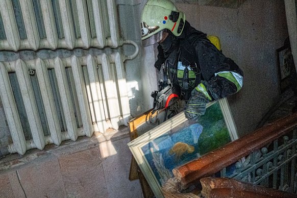A rescue serviceman carries paintings from the burning museum.