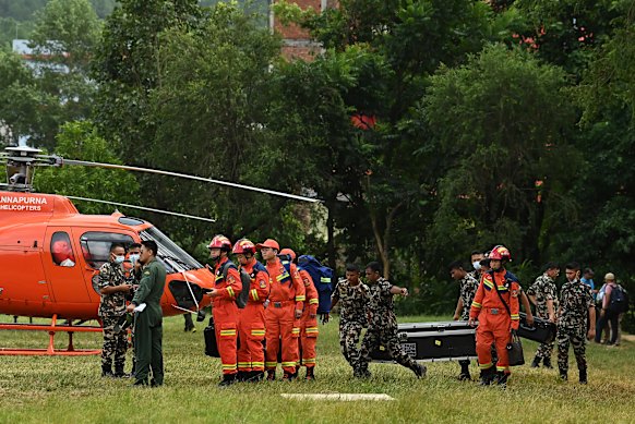 Chinese experts (in orange) with specialist equipment arrive at a Nepalese base in Bidur to assist in the effort to rescue the tunnel workers.