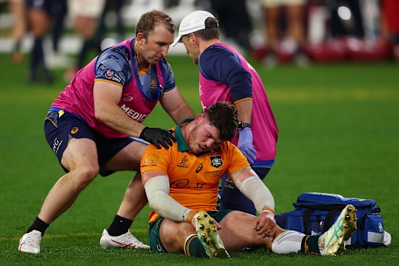 Carlo Tizzano of the Wallabies receives medical attention after the clash with Jac Morgan.