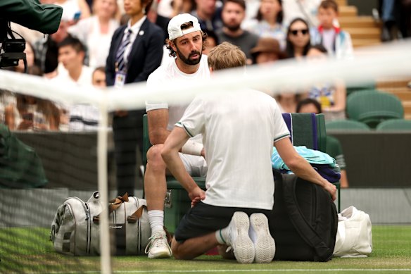 Thompson speaks to the trainer about his injury, shortly before leaving the court for a medical timeout.