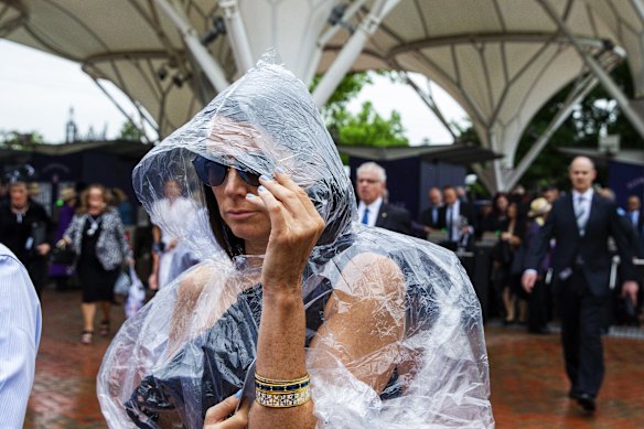 A racegoer resorts to a poncho on Derby Day in 2019.
