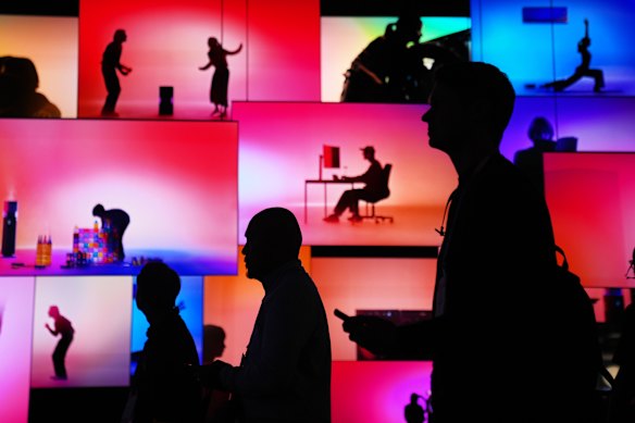 People pass an LG Electronics display during the CES tech show in Las Vegas.