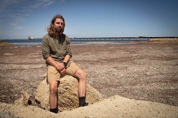 Marine biologist Stefan Andrews at Port of Ardrossan, where dead sea grasses stretch towards the horizon.