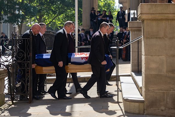 The coffin arrives ahead of the state funeral for Graham Richardson, draped in the St George Dragons flag.