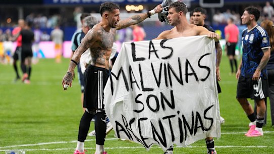 Giovani Lo Celso and Nicolas Otamendi hold the banner.