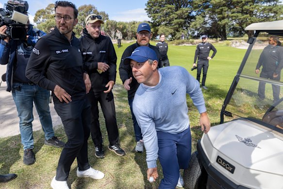 Rory McIlroy throws a golf ball to a young fan. 