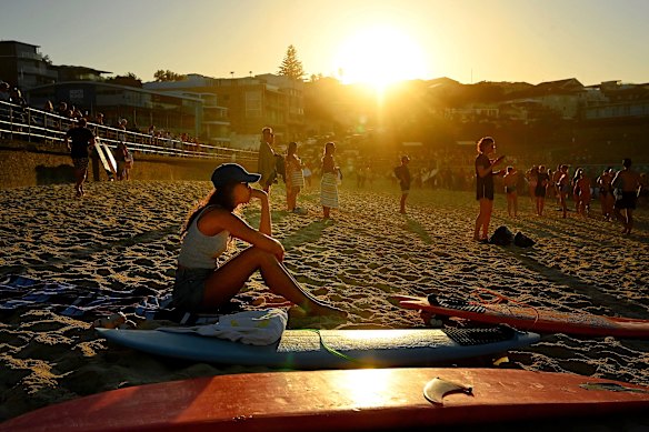 A woman sits on Bondi Beach before a “paddle out” to pay tribute to the victims. 