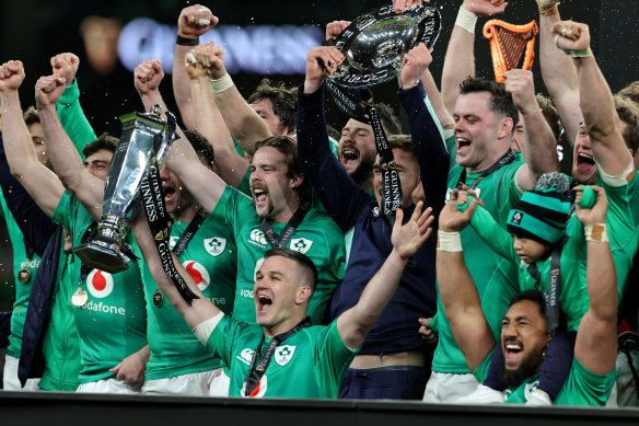 Johnny Sexton, the Ireland captain, holds the Six Nations trophy arsenic  Ireland observe  their Grand Slam victory.