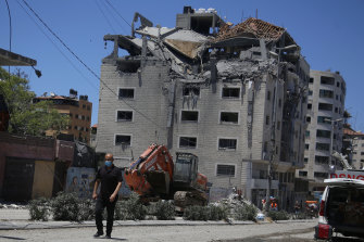 Un Palestinien passe devant un bâtiment touché par une frappe aérienne israélienne à Gaza.