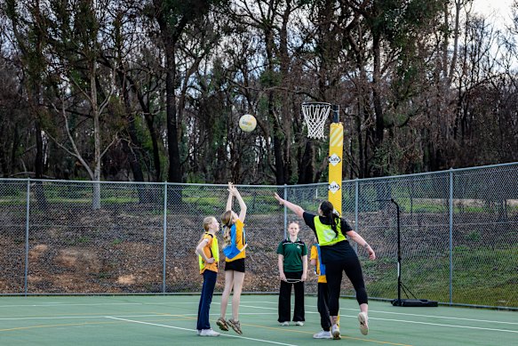 Coach Shelby (right) takes junior netball training at Harcourt. The fire ran to the fence.