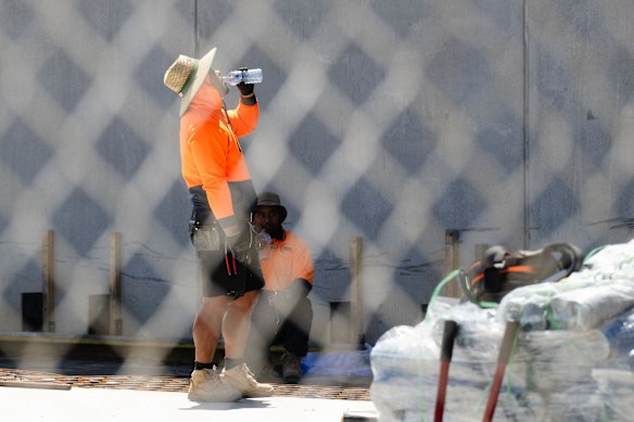A worker stops for a break on Friday, a scorching day in Gregory Hills, Sydney.