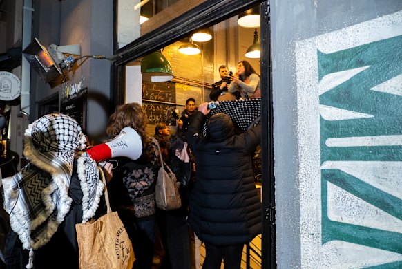 The group yelled and threw chairs outside Miznon on Friday night.
