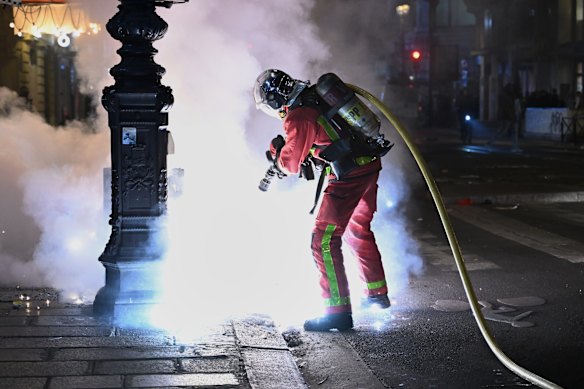 A firefighter tackles a street fire during violence on Sunday.