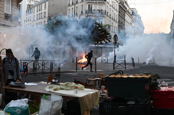 A protester runs through tear gas at a flea market in Paris.