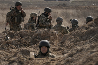 Des militaires ukrainiens se tiennent dans des tranchées à une position au nord de Kiev.