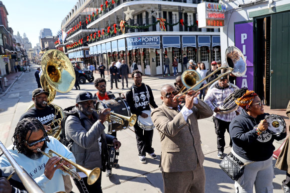 Famed New Orleans musician Glen David Andrews (trombone raised, second from right) performs with a brass band at the end of a “peace walk” down Bourbon Street led by New Orleans mayor LaToya Cantrell.