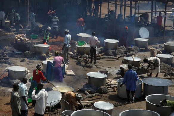Refugees prepare food including maize porridge donated by USAID and known locally as posho, during the visit of UN officials. in Adjumani, Uganda.