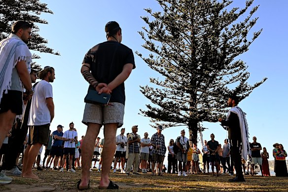 Rabbi Yossi Friedman (right) leads people in prayers at Archer Park last week.