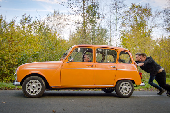 Swedish TV presenters Filip Hammar and Fredrik Wikingsson push the car they drove to France with Filip’s father Lars (inside).