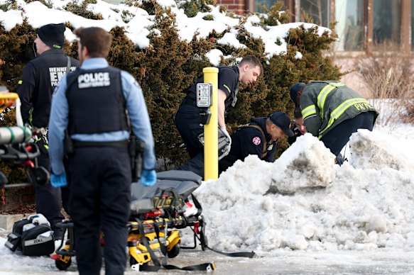 Emergency workers try to help the woman after the shooting.