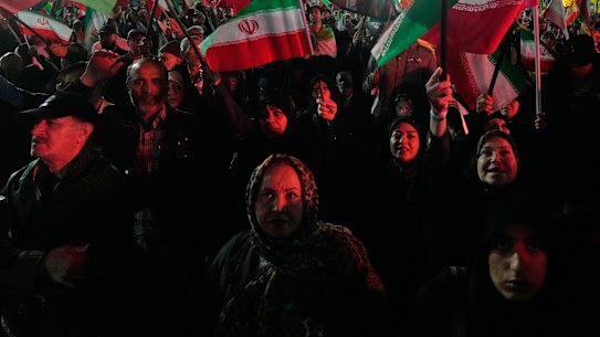 Pro-government demonstrators wave Iranian flags in Tehran on Monday.
