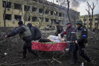 Des employés et des volontaires ukrainiens des urgences transportent une femme enceinte blessée d'une maternité à Marioupol, en Ukraine, le 9 mars 2022. La femme et son bébé sont décédés plus tard.