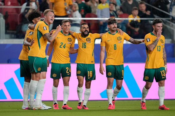 Socceroos players celebrate qualifying for the round of 32