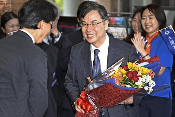 Osaka University professor Dr. Shimon Sakaguchi receives flowers on Tuesday after the win.