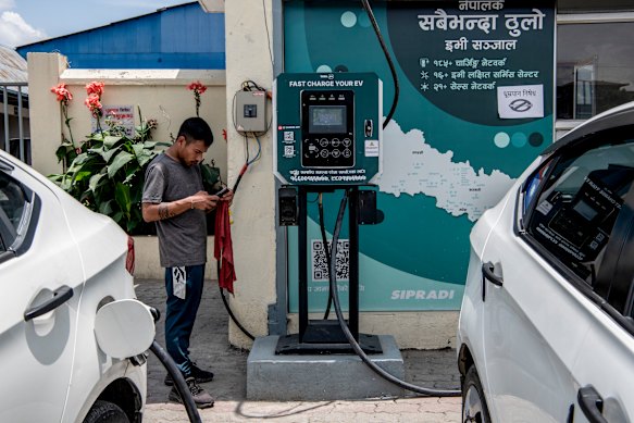 Many taxis in Kathmandu have gone electric. Their drivers use the time while charging to clean their cabs and relax.