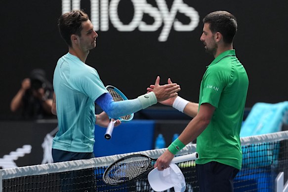 Lorenzo Musetti, left, of Italy shakes hands with Novak Djokovic of Serbia after retiring from their quarterfinal match at the Australian Open.