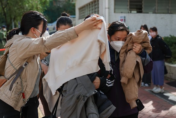 They were shielded by support workers with umbrellas and clothing as they left the community hall where identification was taking place.