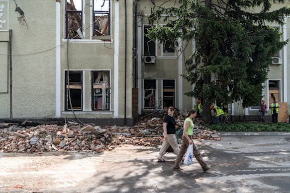 People walk past the scene of a Russia drone attack in Kharkiv last July. 