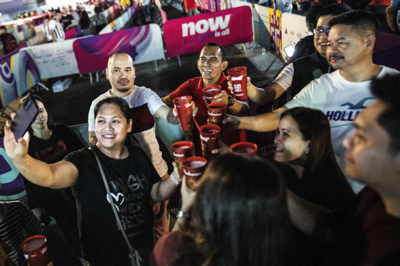 Soccer fans from the Philippines take a selfie after buying Budweiser beer at a fan zone during the World Cup in Doha, Qatar on December. 